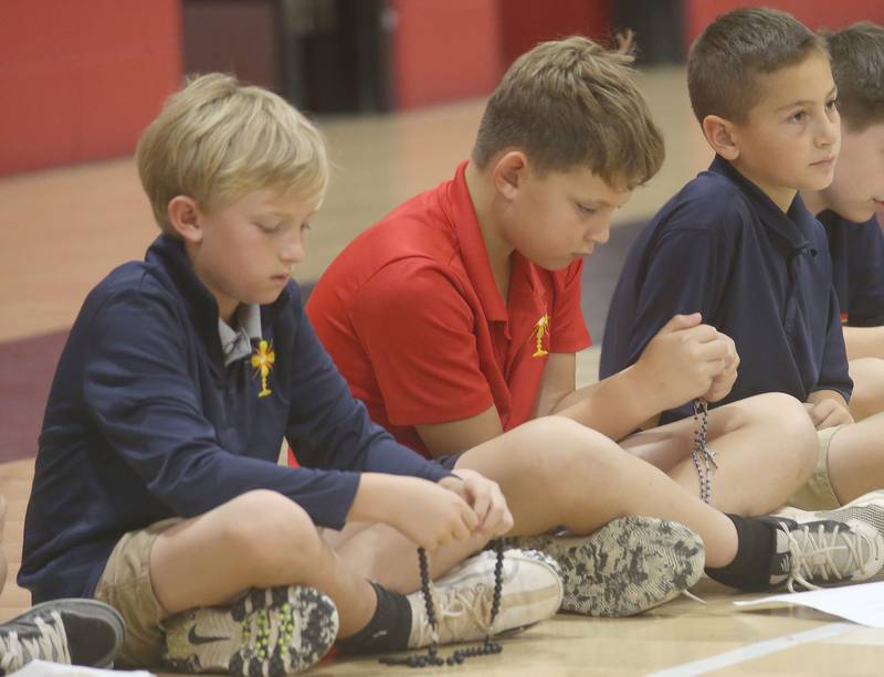 Students (from left) River Rubley, Connor Jasons and Ethan Opsal pray the Rosary during the One Million Children Praying the Rosary campaign on Tuesday, Oct. 7, 2025 at Academy of St. Carlo Acutis Oglesby campus. the campaign is inspired by the words of St. Padre Pio, who believed that “when one million children pray the Rosary, the world will change,” the campaign has grown into a significant spiritual movement, drawing participation from schools, parishes, and families across continents. All over the world, children prayed the rosary on the 7th of October.