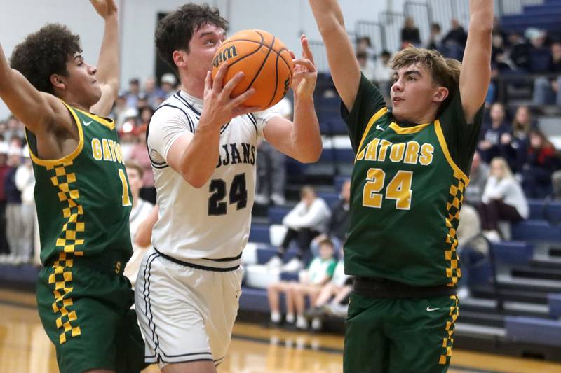Cary-Grove’s Brady Bauer works under the hoop against Crystal Lake South’s Noah Cook, left, and Vince Santarelli, right, in varsity boys basketball on Wednesday, Dec. 3, 2025, at Cary-Grove High School in Cary.