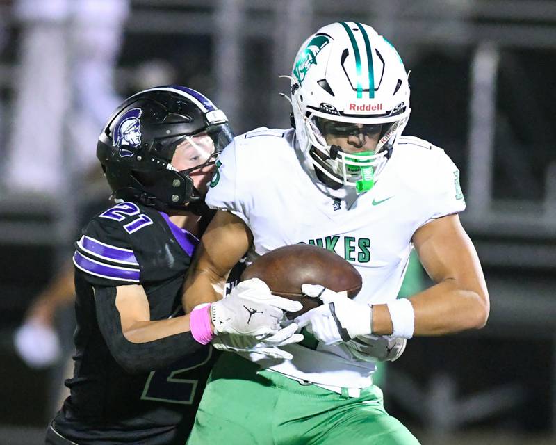 York's Simon Kodosky, right,  catches a pass and runs in for a touchdown during the game on Friday Oct. 10, 2025, while being defended by Downers Grove North's defender Connor Crowley (21)  held at Downers Grove North High School.