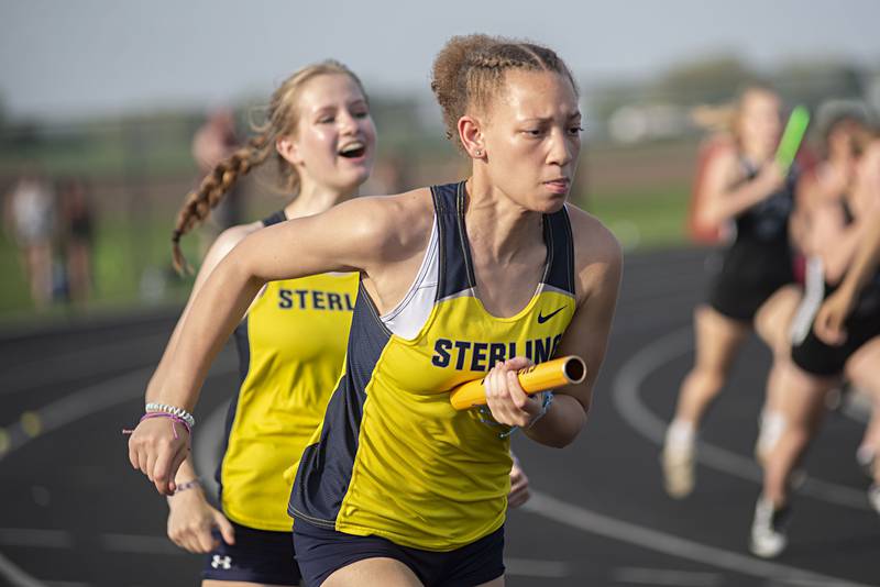 Sterling's Kirra Gibson takes the baton from teammate Anna Aulwes in the 4x100 at the 2A track sectionals in Geneseo on Wednesday, May 11, 2022.