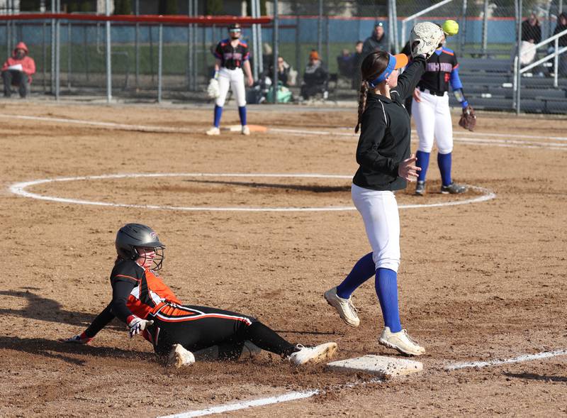 Genoa-Kingston’s Olivia Vasak takes the throw as Winnebago’s Brynn Bridger slides in safely at third during their game Monday, April 21, 2025, at Genoa-Kingston High School.