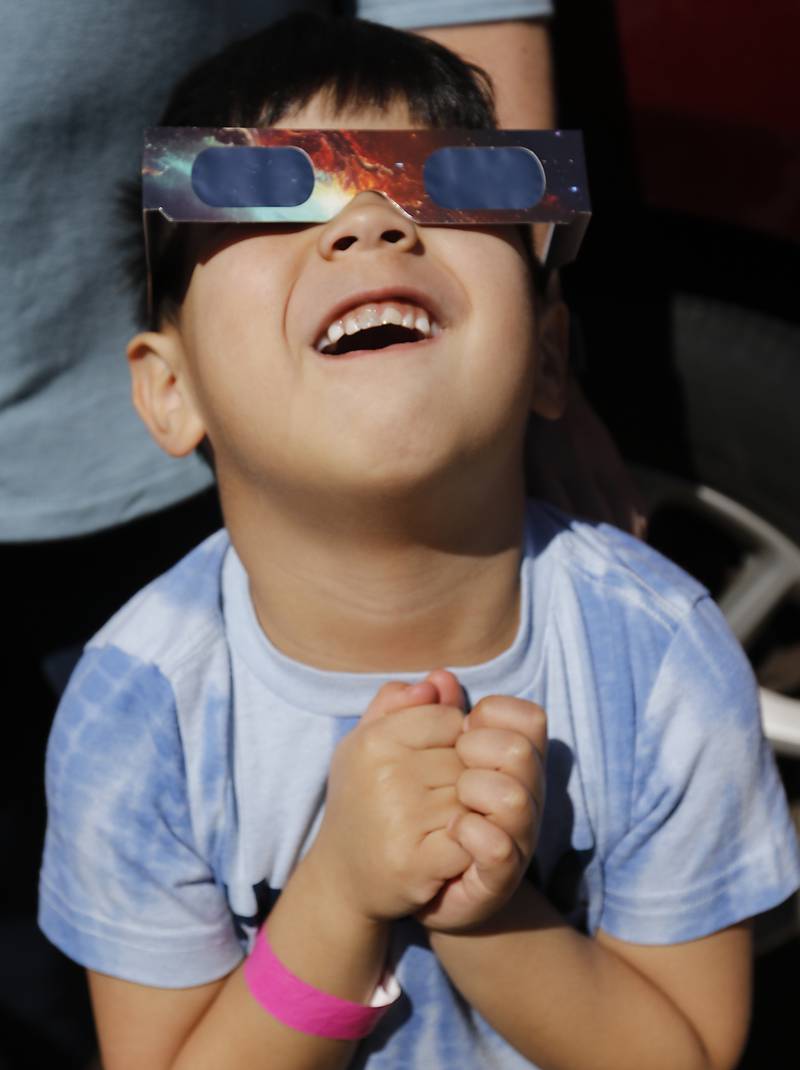 Tyson Josue, 4, of Crystal Lake gazes at the sun after putting on the eclipse glasses on  Monday, April 8, 2024, at the Crystal Lake Park District's Nature Center.