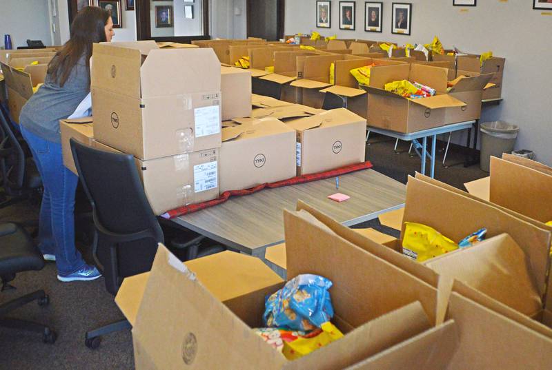 Illinois Valley Community College employee volunteer Nikki VanNielen seals boxes of supplies before they're distributed for Thanksgiving.