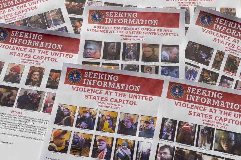 Seeking information flyers produced by the FBI are photographed on Dec. 20, 2021. The Justice Department has undertaken the largest investigation in its history with the probe into rioters who stormed the Capitol on Jan. 6. (AP Photo/Jon Elswick