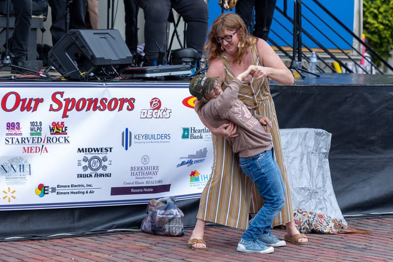 Tricia Pinter “dips” Kyla Kissick during “Brass From The Past” performance at the annual Shrimp Fest on Saturday, June 7, 2025 at Rotary Park in Princeton.