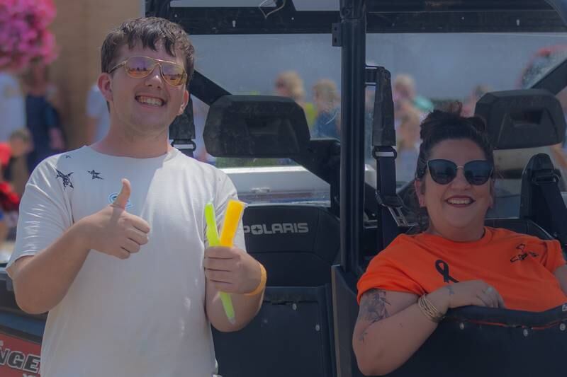 Conner Wolf and his mom, Erin, represent Complete Autoworks Repair Services in Dixon during the Petunia Festival Parade on Sunday, July 7, 2024.