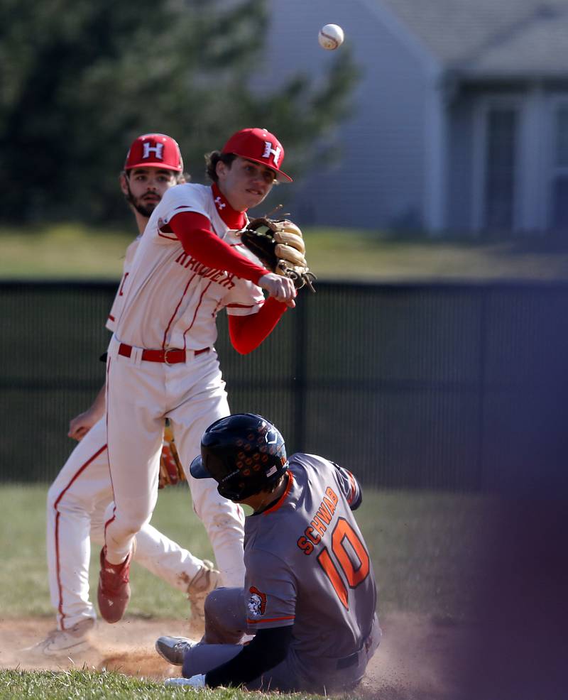 Huntley's Tyler Jakubowski turns a double play as Jeffry Schwab slides into second base during a Fox Valley Conference baseball game on Friday, April 11, 2025, at Huntley High School.