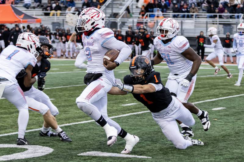Lincoln-Way West's Jackson Mansker tries to slowdown Kenwood's Kenyonte Louis during a 7A varsity football playoff game at Lincoln-Way West on Nov. 8, 2025.