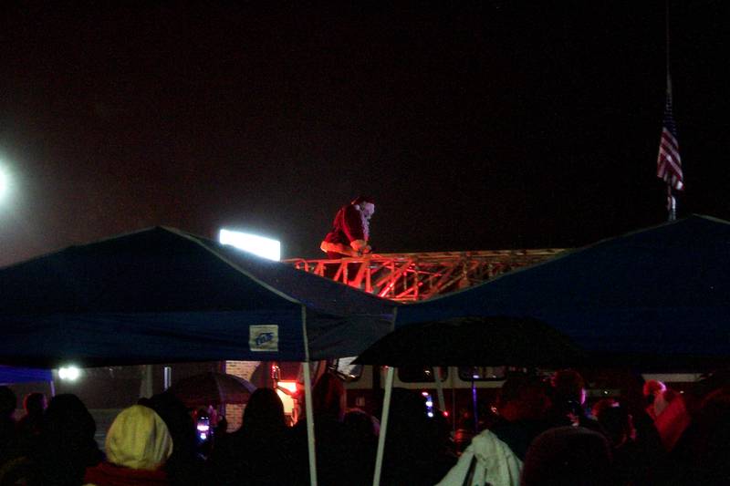 Santa Claus makes his way off of a Montgomery fire truck, to light the Christmas tree in front of Village Hall Dec. 5.