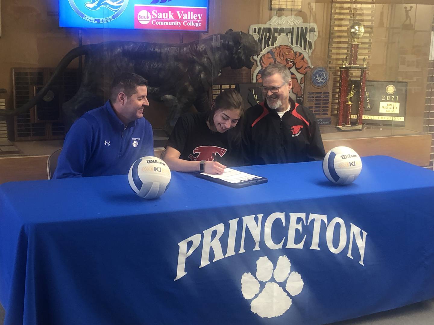 PHS senior Maya Gartin signs Tuesday to play volleyball for Sauk Valley under the watchful eye of PHS coach Andy Puck (left) and Sauk coach Jay Howell (right).