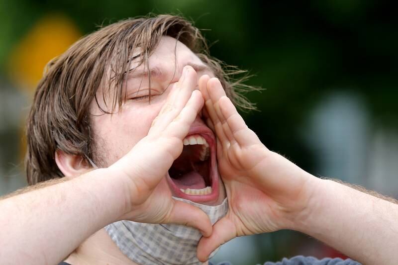 James Boerschinger of Crystal Lake cups his hands around his mouth as he yells "I can't breathe" during a Black Lives Matter protest on Friday, June 5, 2020 in downtown Crystal Lake. More than a hundred peaceful protesters stood and chanted with signs for two hours at the 5-way stop intersection of Walkup Ave, Crystal Lake Ave, and Grant St. Every 20 minutes, the group moved into the crosswalks to block traffic for 7 minutes to raise awareness for the social injustices faced by African American people across the country. Protesters marched peacefully but vocally down Grant St and East Woodstock St to Depot Park to listen to speakers share their experiences and offer ideas to help society battle racism.