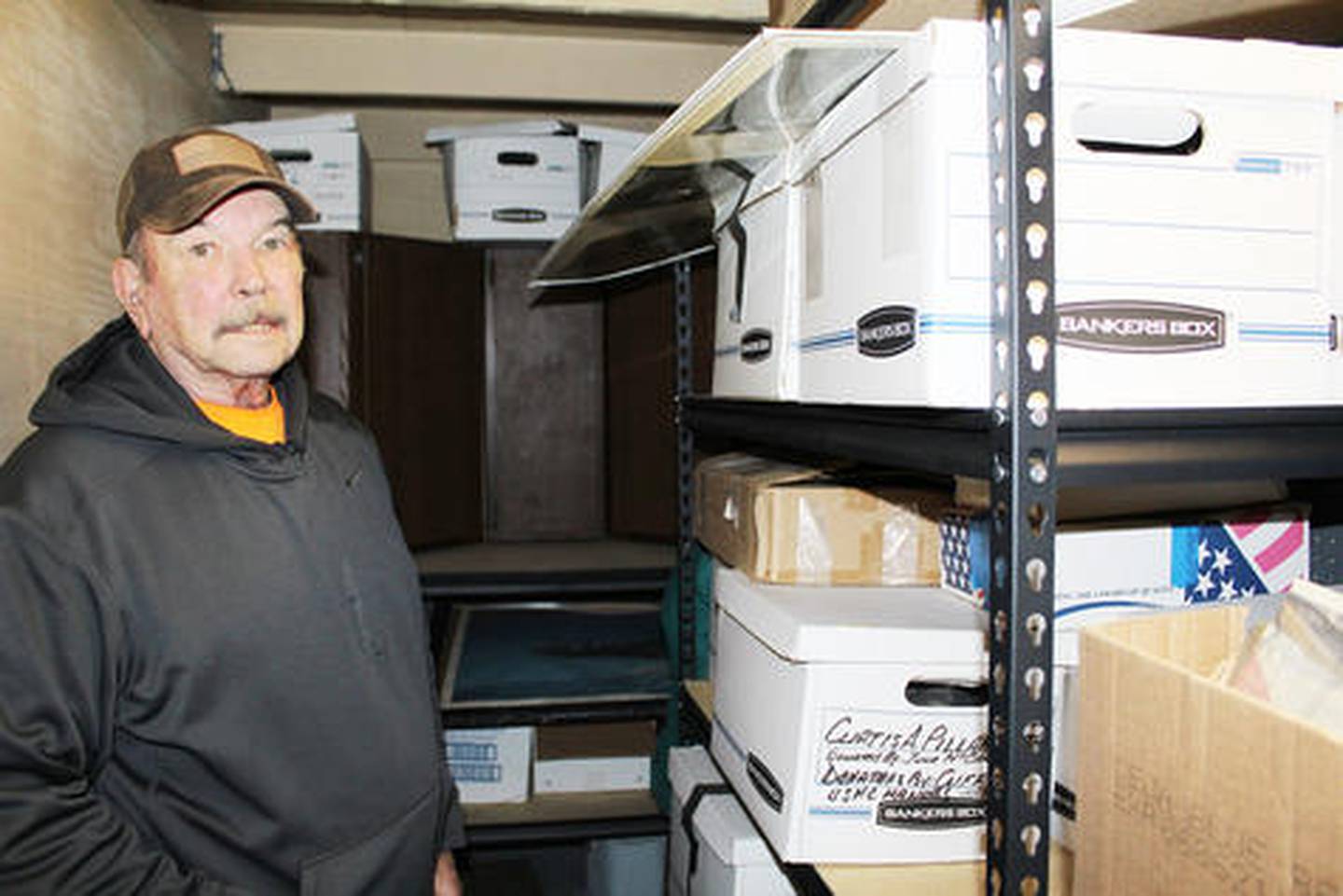 Al Wikoff, one of the commissioners of the Veterans Memorial Park and Museum, goes through some of the boxes collected of donations for the museum.