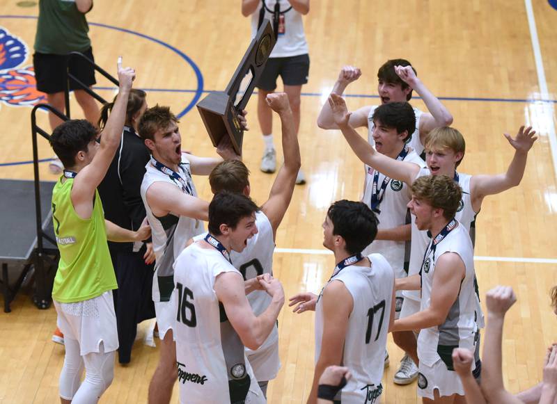 Paul Valade/pvalade@dailyherald.com
Glenbard West's Gavin Swartz, second from left, lifts the first-place trophy for his teammates to see after they defeated Lincoln-Way East in Saturday’s IHSA state boys volleyball championship match in Hoffman Estates.