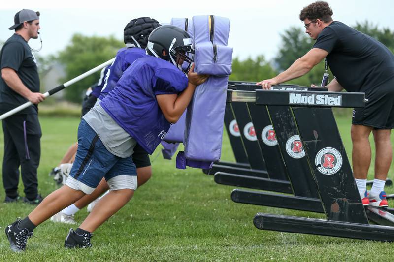 Plano's line hits the sled at Plano High School football practice.  August 9, 2023.