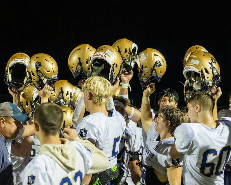 Marquette players hold up helmets after win against Dwight in week 4 on Friday, Sept. 19, 2025 at Dwight High School in Dwight.