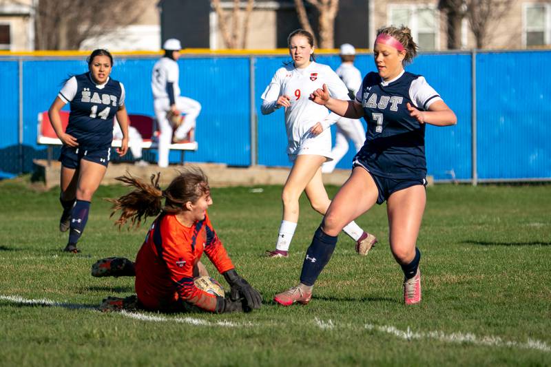 Oswego’s Amara Loghmani (1) makes a diving save against Oswego East's Gabby McPhee (7) during a soccer match at Oswego East High School on Thursday, Apr 6, 2023.