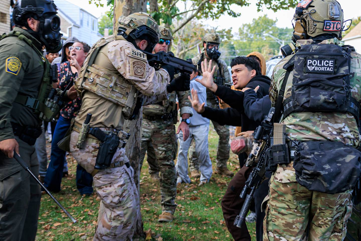 A law enforcement officer points a crowd control weapon at a protester in East Side, Chicago, Tuesday, Oct. 14, 2025. (Anthony Vazquez/Chicago Sun-Times via AP)
