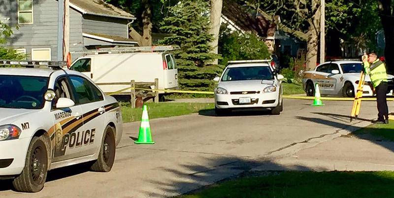 A police officer takes measurements outside a home at 709 E. Prairie St. in Marengo on Sunday morning after an incident where a Marengo officer shot a boy May 13.
