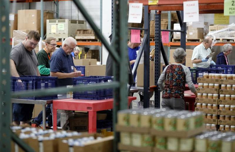 Volunteers pick and package food Thursday at the Northern Illinois Food Bank in Geneva. The food bank, which serves about 78 million meals a year to people in need, is among the recipients of a grant from the Daily Herald Neighbors in Need partnership with the McCormick Foundation.