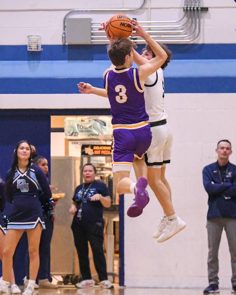 Downers Grove North's Nolan Hurter (3) takes a shot while being defended by crosstown rival Downers Grove South's Wyatt Wawro (5) during the game on Saturday Dec. 21, 2024, held at Downers Grove South High School.