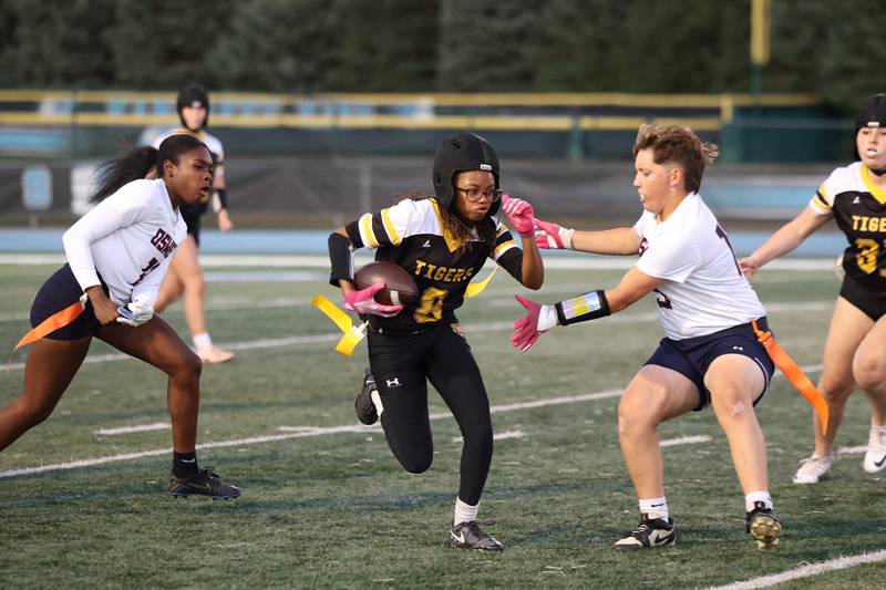 Joliet West's Londyn Clemons evades Oswego's Mak Hill, right, and Jazmin Hurston during the Panthers' 13-7 victory over Joliet West on Tuesday, Oct. 7, 2025.
