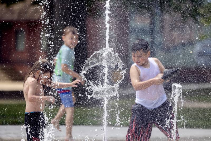 Santiago Tavares, 7, swipes at a stream of water while playing with friends at Sterling’s new Grandon Civic Center splash pad on Wednesday, May 31, 2023. The new pad is open 9 a.m. to 8 p.m. except on days of a Municipal Band concert.