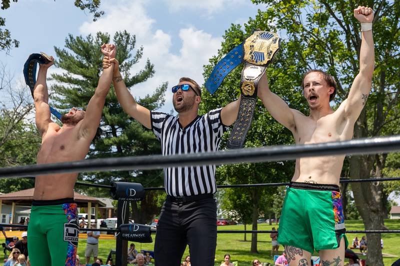 (center) Kevin Woods crowns (left, right) Davey Bang and August Matthews of 'Bang and Matthews' as the new Tag Team Champions after defeating 'The Hype' at the Taste of the Illinois Valley DreamWave Wrestling event on Saturday, August 2, 2025 at Centennial Park in Peru.