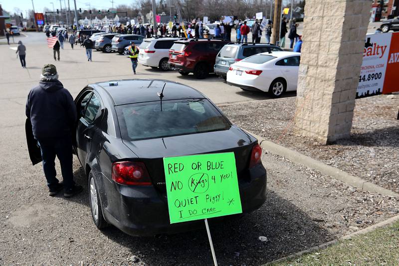 A man looks out at the protesters lining  State Route 31 near the intersection of McCullom Lake Road in McHenry to protest their discontent with President Donald Trump and his administration's policies on Saturday, March 28, 2026, during the McHenry County No Kings Protest. According to an organizer, over 4,000, people took part in the protest.