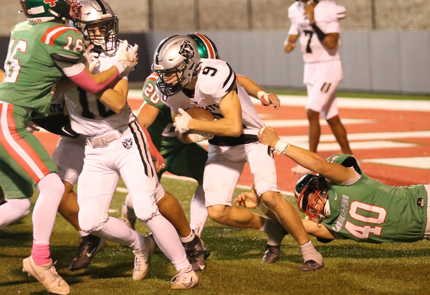 Kaneland's Carter Grabowski tries to break free of L-P defenders Grifin May (20) and Nick Hachenberger (40) on Friday, Oct. 17, 2025 at Howard Fellows Stadium.