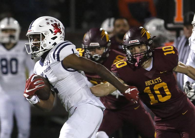 St. Viator's Dayvion Ellis tries to get out of the grasp of Richmond-Burton's Max Loveall during a IHSA Class 4A first round playoff football game Friday, Oct. 27, 2023, at Richmond-Burton High School in Richmond.