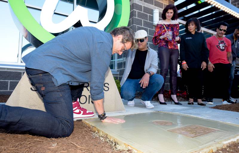 Joey McIntyre signs his name an places a hand print in wet cement during the Wahlk of Fame Ceremony for New Kids on the Block at the Wahlburgers in St. Charles on Saturday, June 18, 2022.