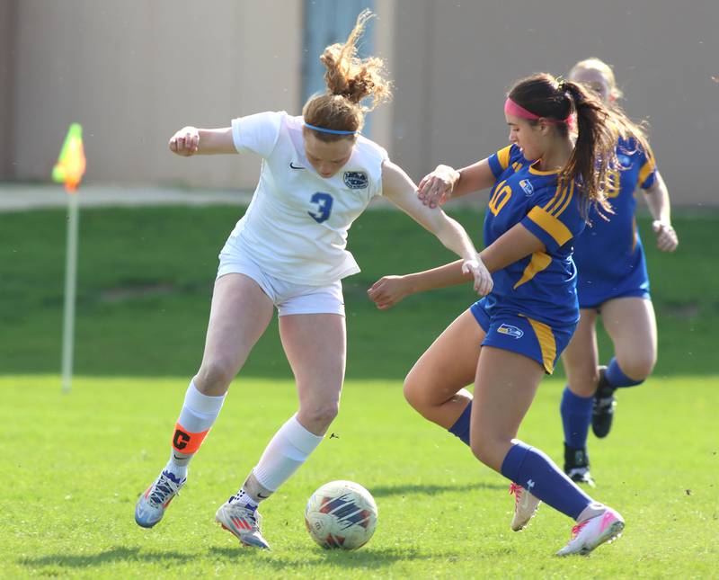 Johnsburg’s London Baldinger, right, battles Woodstock’s Keira Bogott, left, in varsity soccer on Wednesday, April 23, 2025, at Johnsburg High School in Johnsburg.
