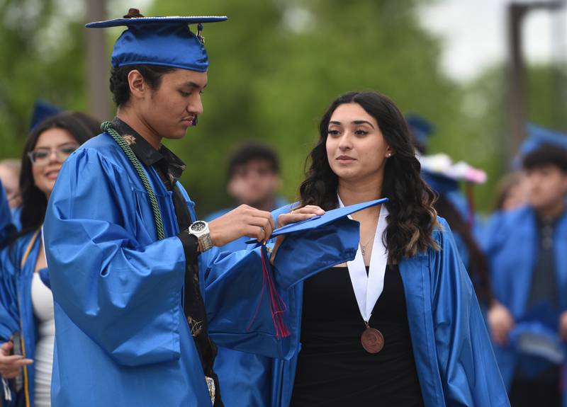 Dundee-Crown High School senior Rey Capetillo, left, adjusts the tassle for his sister, Julyeta Capetillo before the start of the graduation ceremony on Saturday, May 21 at the Now Arena in Hoffman Estates.