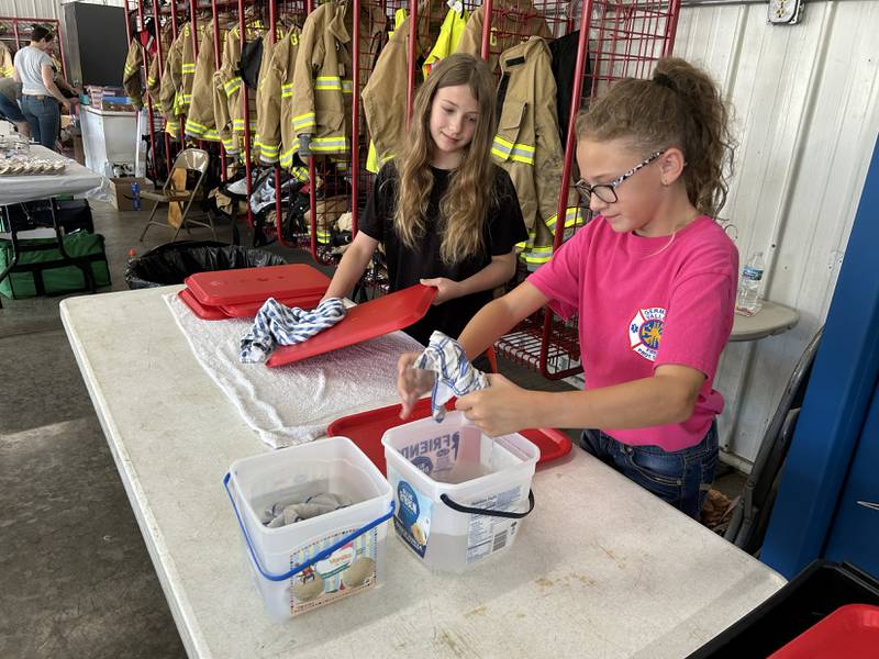 Paisley Deboer (left) and Jocelyn Julius were busy washing trays at the German Valley Fire Department's annual pork chop dinner fundraiser at German Valley Days on Saturday, July 19, 2025.