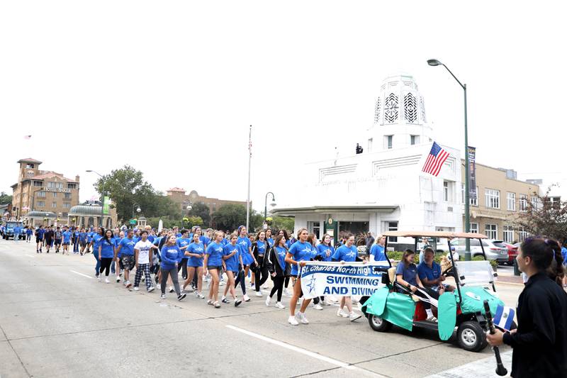 Members of the St. Charles North swim and dive team marches along Route 64 on Friday, Sept. 27, 2024 during the school’s annual homecoming parade in St. Charles.