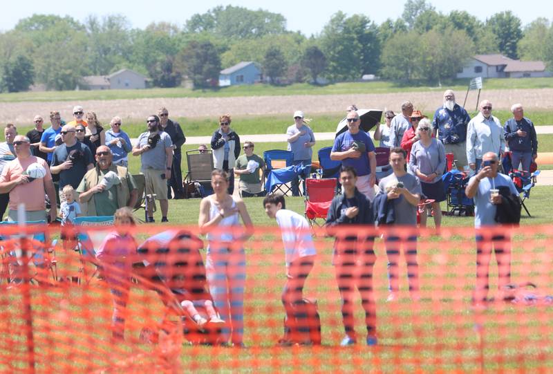 Spectators stand for the National Anthem during the 11th annual TBM Reunion and Air Show on Friday, May 15, 2026 at the Illinois Valley Regional Airport in Peru.