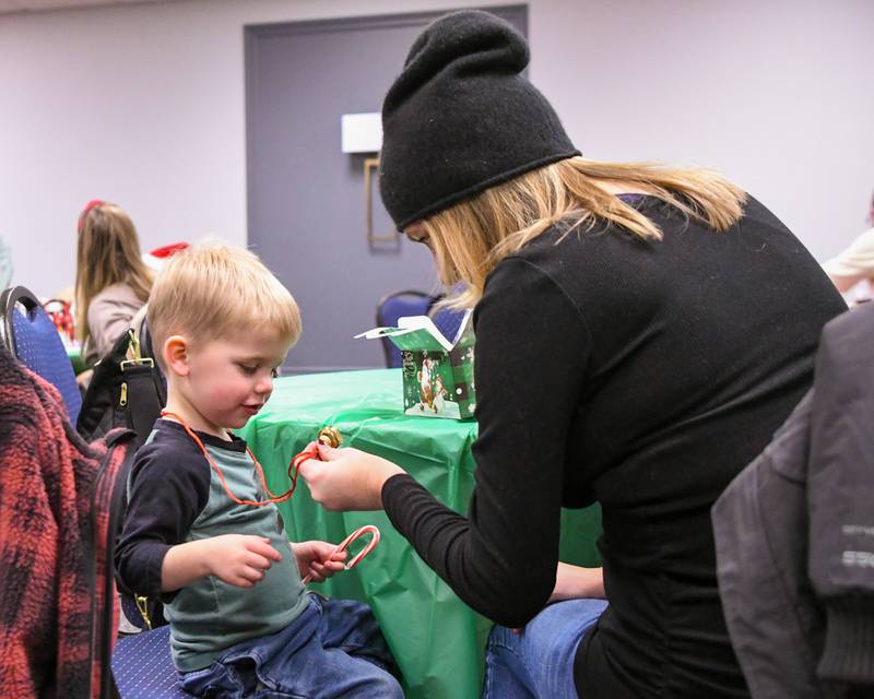 Frank Ricciardi,2, looks at the neckless bell that his mom Christina Ricciardi of La Grange put around his neck that was found inside the goodie bag on Sunday Dec. 15, 2024, during the breakfast with Santa event held at the La Grange Park District Recreation Center.