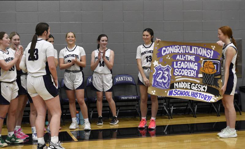 The Manteno bench holds up a sign congratulating Maddie Gesky, left, on becoming the school's all-time leading scorer during a game against Herscher on Thursday, January 15, 2026.