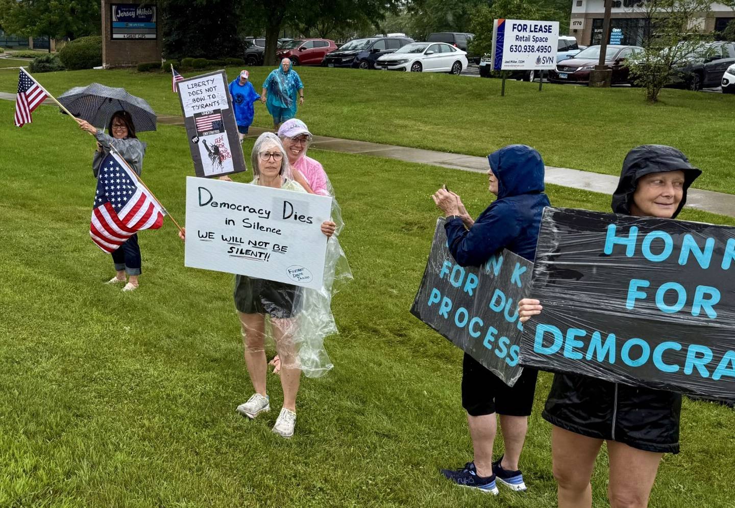 Participants at the "Together for Justice" rally, organized by We Can Lead Change Fox Valley hold signs in protest on South Randall Road near Gleneagle Drive in Geneva on Saturday, July 19, 2025.