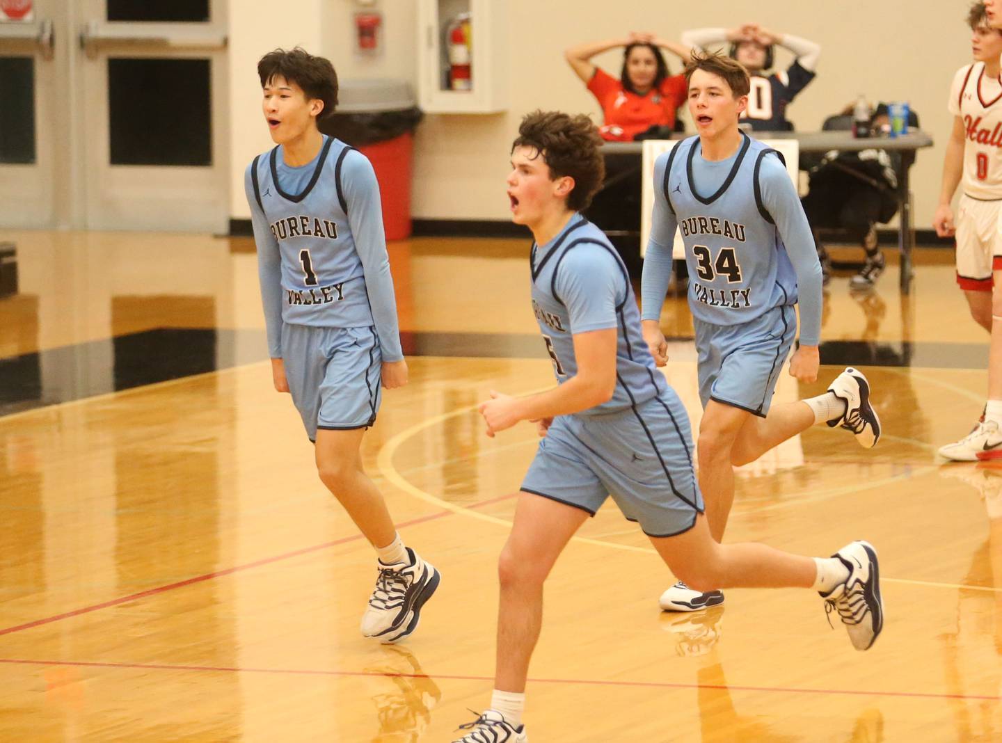 Bureau Valley players Carter Chhim, Logan Philhower, and Carson Gruber react after defeating Hall on Wednesday, Jan. 28, 2026 at Hall High School.