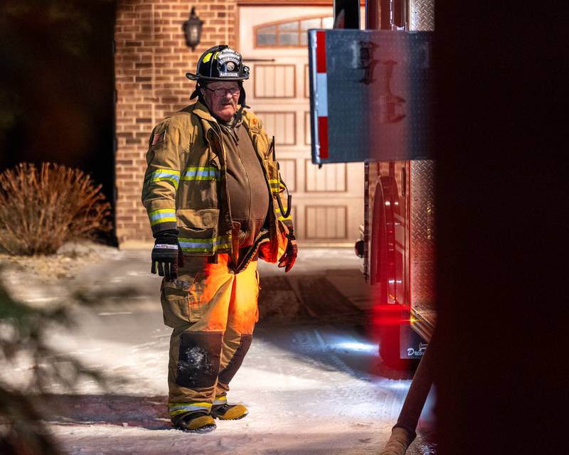 Local Firefighter stands beside Firetruck on scene of a structure fire at 3903 East 550th Road on Saturday, Jan. 31, 2026 in Mendota. The fire started in the chimney area. Fire departments from Troy Grove, Utica, La Salle, Peru, Mendota, and others across the region were dispatched shortly after 10p.m.