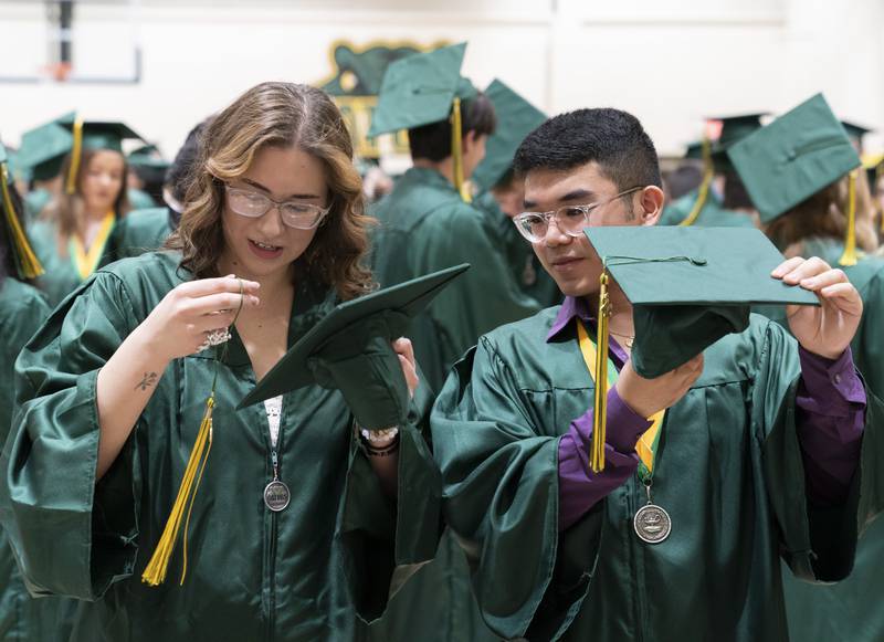 Andi Anderson and Michael Andal adjust their tassels before a graduation ceremony for the class of 2022 on Saturday, May 14, 2022, at Crystal Lake South High School in Crystal Lake.