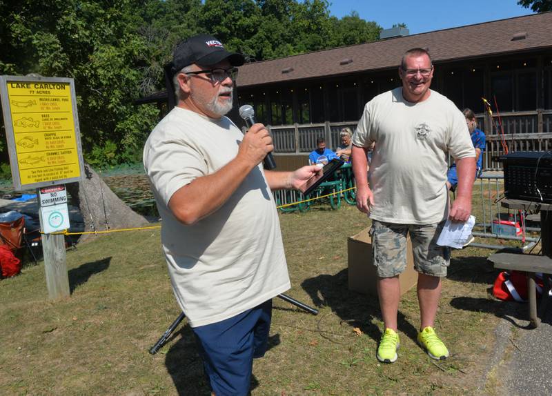 Former Whiteside County Sheriff Kelly Wilhemi accepts an appreciation plaque as current sheriff John Booker listens at the Whiteside County Sheriff Office and Mounted Patrol's annual fishing derby at Morrison-Rockwood State Park in Morrison on Saturday, Sept. 9, 2023.