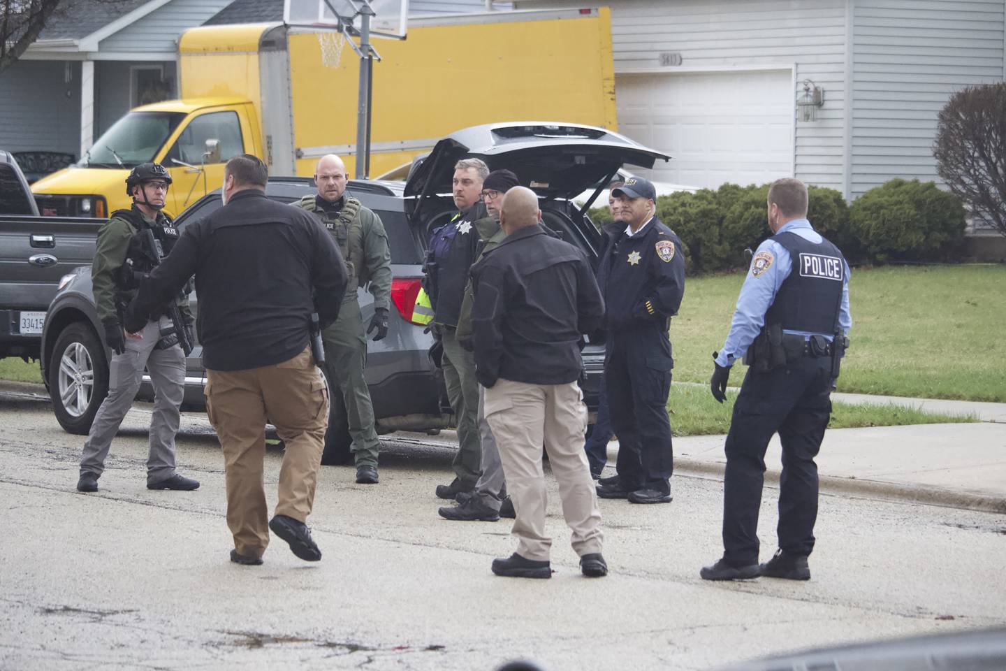 Joliet police officers and detectives gather on April 2, 2025, in the area of Meadowbrook Street and Lasser Drive in the far west side of joliet.