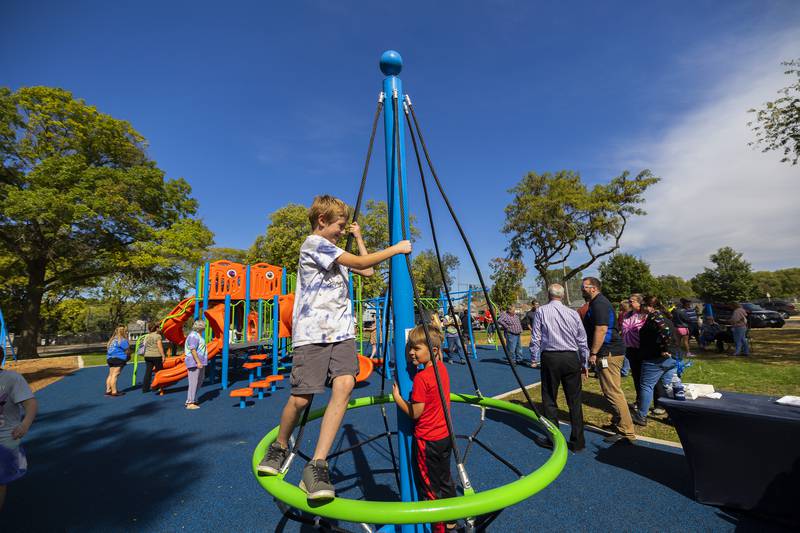 Sedrick Oliver (left), 8, and Max Rosquist, 5, spin on a playground feature Thursday, Oct. 5, 2023 during the official opening of the new playground at Vaile Park in Dixon.