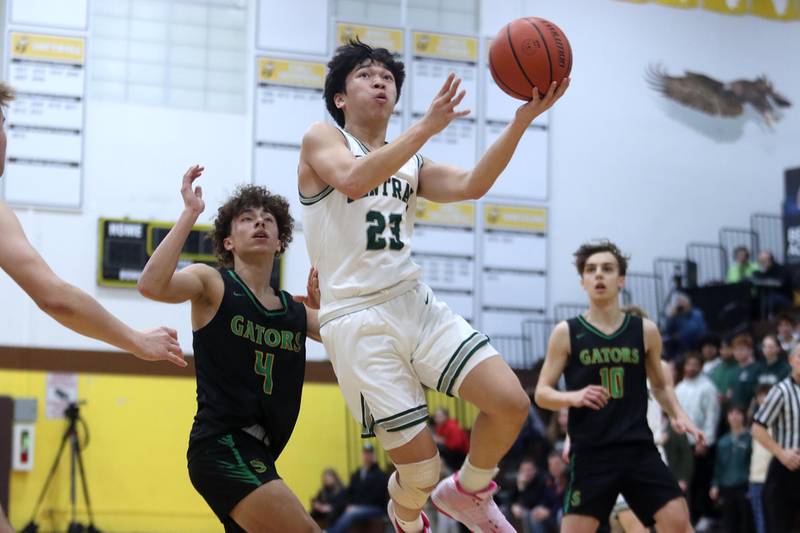 Grayslake Central’s Jayden Hall, center, soars to the hoop past Crystal Lake South’s AJ Demirov during Hinkle Holiday Classic Basketball Tournament title game action at Jacobs High School Friday.