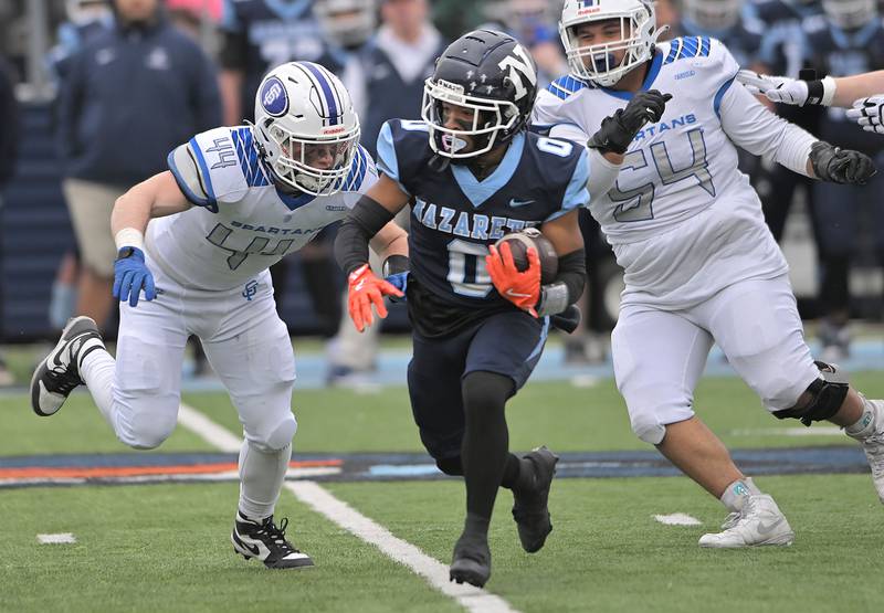 Nazareth’s Edward McClain runs against St. Francis’ Ryan Palmeri and Jaylen Torres, right, in the IHSA Class 5A state semifinal football game in La Grange on Saturday, Nov. 23, 2024.