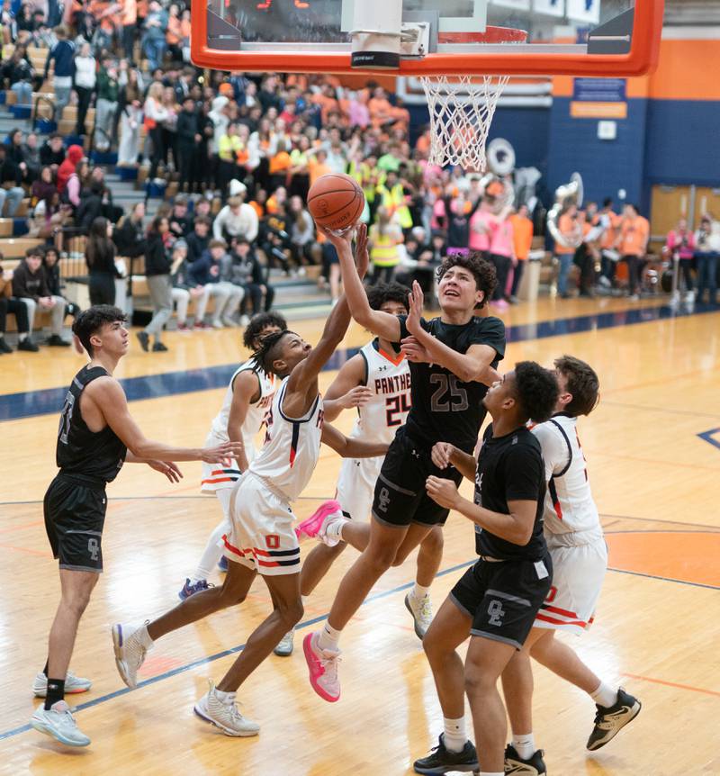 Oswego East's Damien Lewandowski (25) shoots the ball in traffic against Oswego during a basketball game at Oswego High School on Tuesday, Dec 12, 2023.