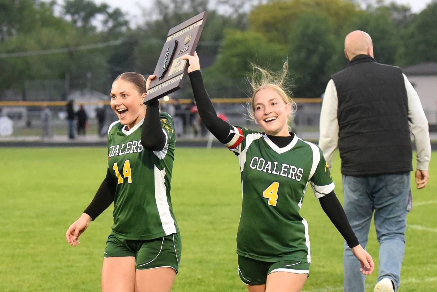 Coal City girls soccer captains Kylee Kennell, left, and Corinna Barkley hoist the IHSA Class 1A Manteno Regional championshop plaque after the Coalers' 4-0 win over Beecher Tuesday, May 20, 2025.