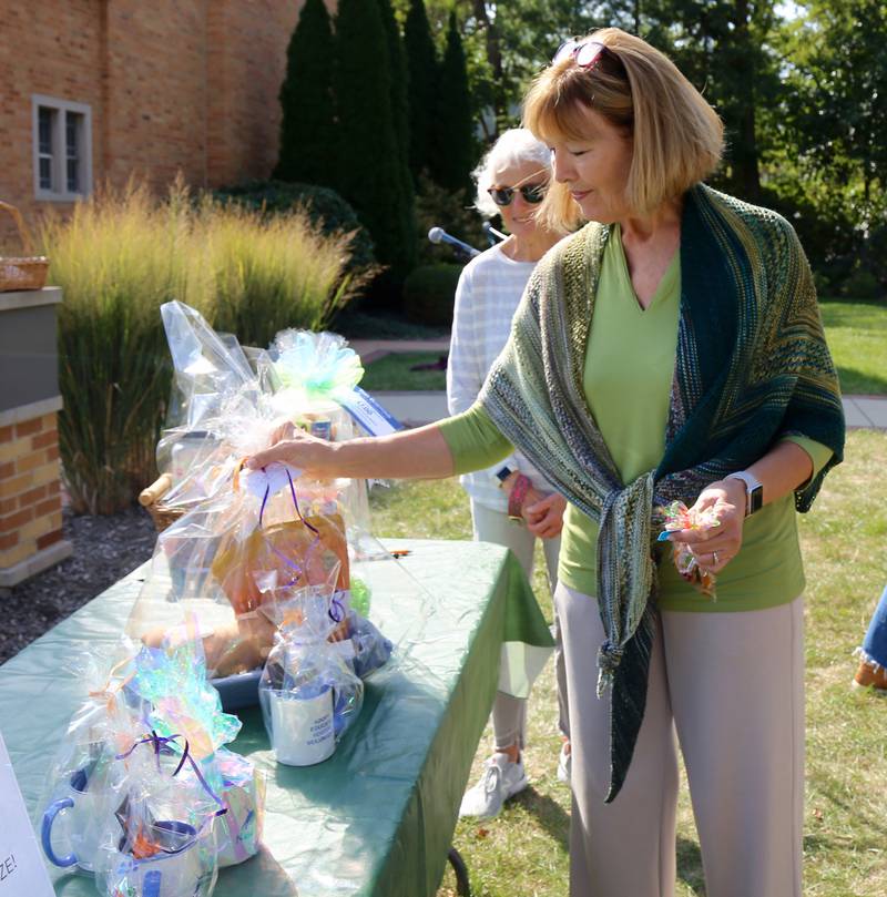 Robin Perrone chooses a prize she won in a raffle that was held after the Blessing of the Animals at Geneva Lutheran Church on Saturday, Oct. 5, 2024.